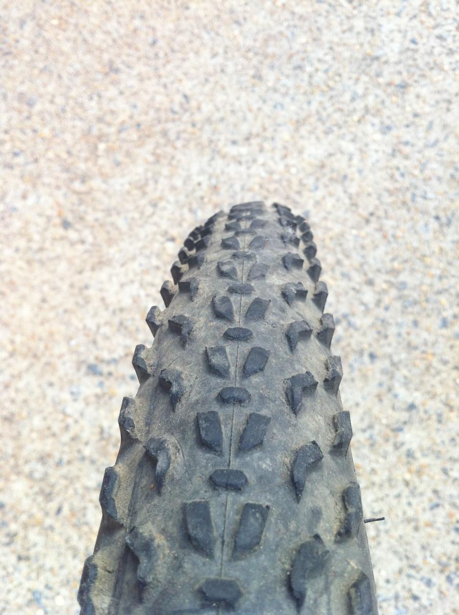Specialized Fast Trak LK Pro: Close-up view of a mountain bike tire showing its tread pattern on a gravel surface. The tire has prominent knobs designed for grip on rough terrain.