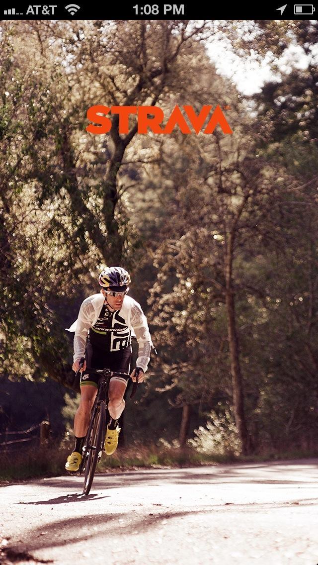 Strava: A cyclist in athletic gear riding a road bike along a tree-lined path, with the Strava logo prominently displayed at the top of the image. The scene captures a sunny day in nature, highlighting the rider's focused expression and dynamic motion.