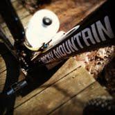 Rocky Mountain Vertex 990 rsl 2013: A close-up view of a mountain bike frame displaying the brand name "Rocky Mountain," set against a wooden surface with natural elements in the background.
