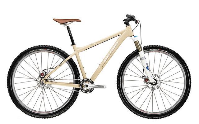 Gary Fisher Rig 29er: A beige mountain bike with a brown saddle, featuring thick tires, disc brakes, and front suspension, positioned on a white background.
