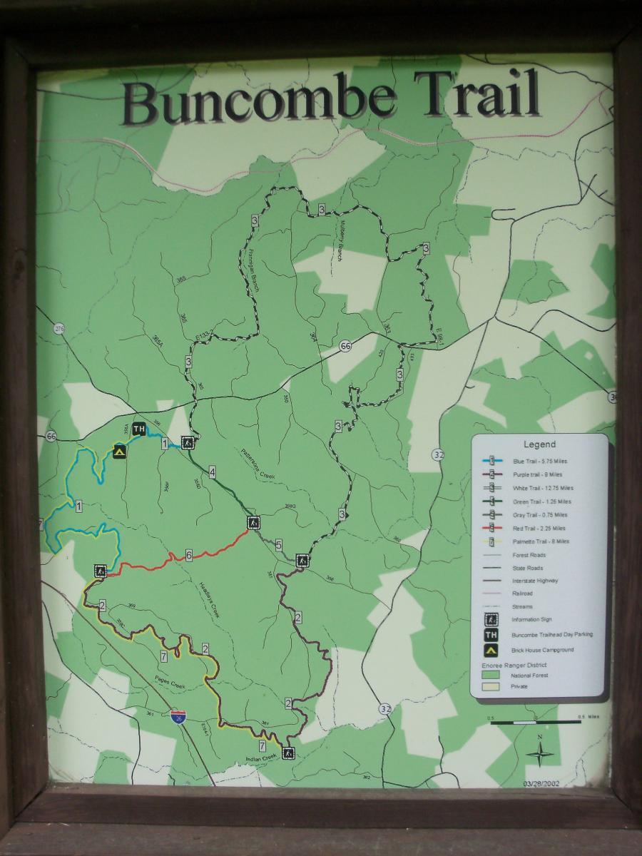 Map of the Buncombe Trail, featuring various paths and trails indicated in different colors, with a legend explaining trail lengths and features such as campgrounds and parking areas. The map is set against a green background, highlighting the surrounding terrain and waterways. Buncombe - Brickhouse Recreation Area mountain bike trail.