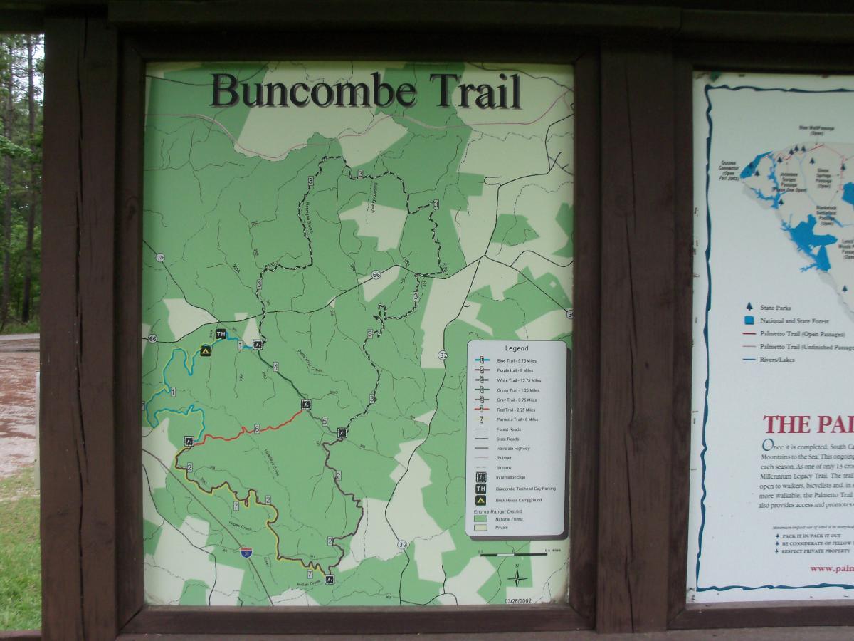 Map of the Buncombe Trail, showing various hiking paths and their lengths, alongside a legend explaining trail markings. The map features green areas representing forested regions and indicates nearby roads and points of interest. Buncombe - Brickhouse Recreation Area mountain bike trail.
