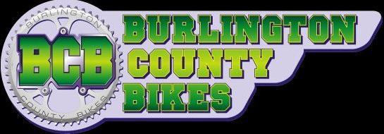 Logo for Burlington County Bikes (BCB) featuring bold lettering in green and blue, with a bicycle gear graphic incorporated into the design.