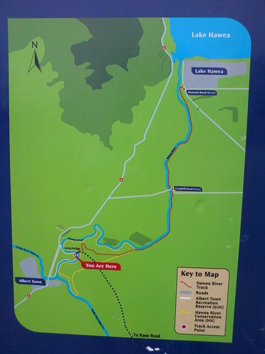 Map of the Lake Hawea area, showing trails, roads, and key landmarks. The location marked "You Are Here" indicates the current position near the Hawea River and swing bridge, with surrounding features labeled including Albert Town and access points. Hawea River Track mountain bike trail.