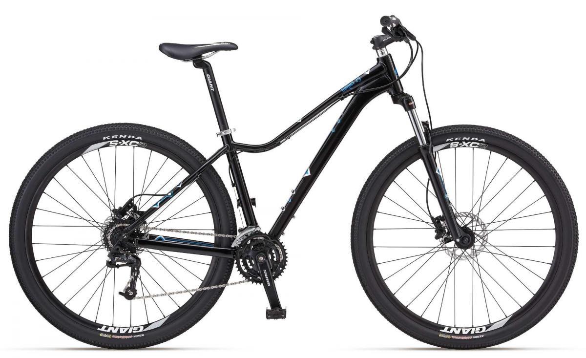 Giant 2012 Rainier 29er W: A black mountain bike featuring a lightweight frame, front suspension, and wide tires designed for off-road trails. The bike is equipped with a Shimano gear system and has a sleek, modern design with blue accents.