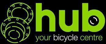 Logo for Hub Bicycle Centre featuring the text "hub" in bold green letters, with "your bicycle centre" in smaller text below. Two circular bicycle gear graphics are positioned on the left. The background is black.