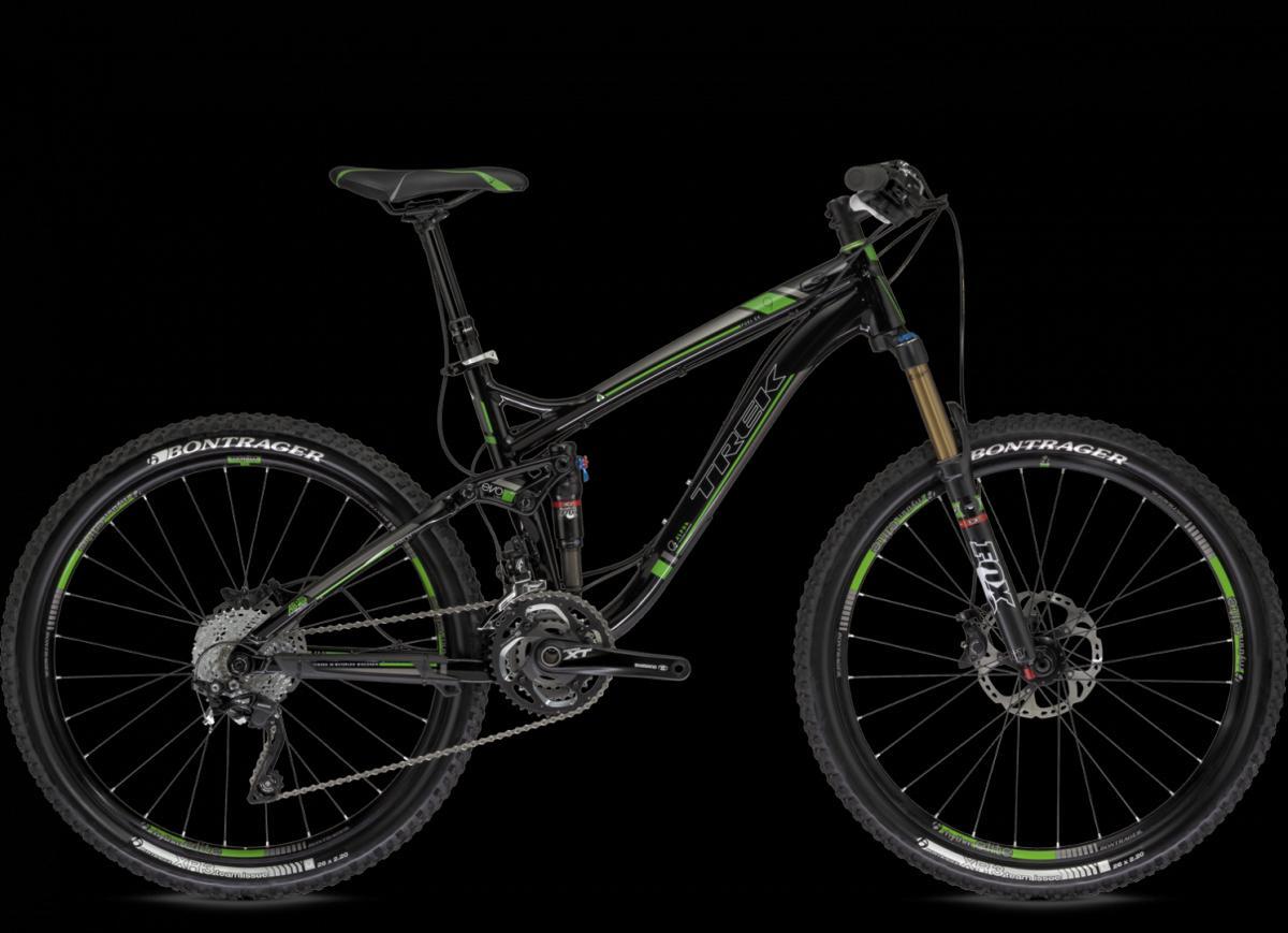 Trek Fuel EX 9.8: A black and green mountain bike with a sleek design, featuring a full suspension system, disc brakes, and detailed gearing components. The bike is set against a black background, highlighting its modern aesthetic.