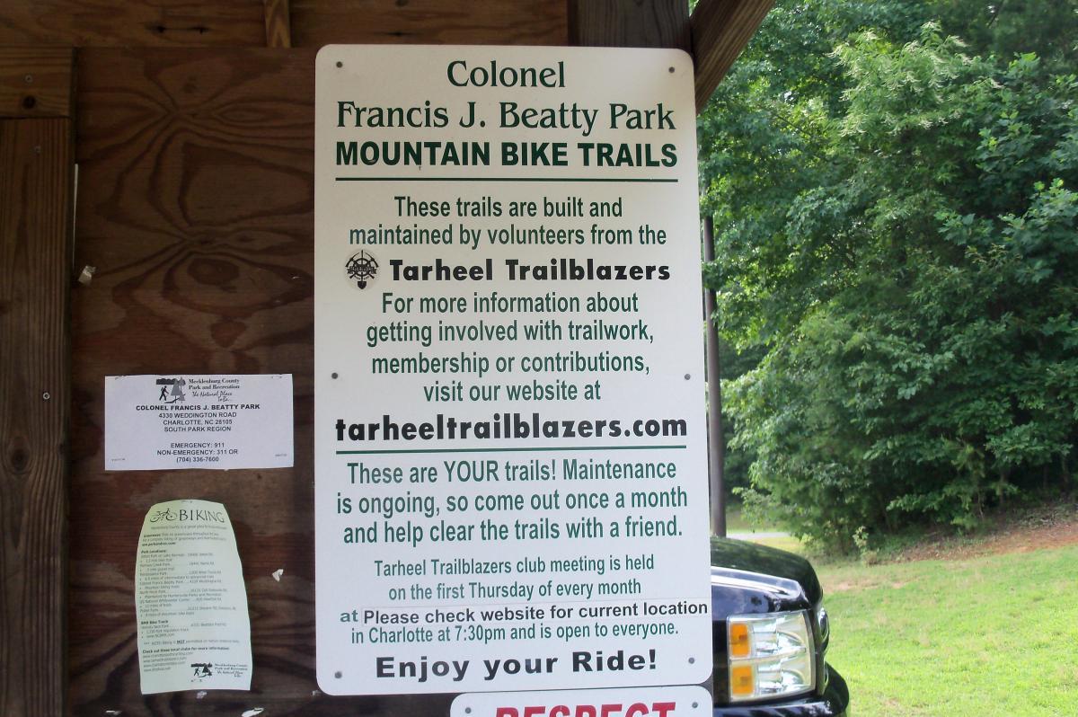 Sign detailing the mountain bike trails at Colonel Francis J. Beatty Park, indicating that the trails are maintained by volunteers from the Tarheel Trailblazers. It includes information on getting involved, the club's meeting schedule, and a reminder to respect the trails. Colonel Francis Beatty Park mountain bike trail.