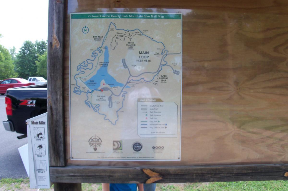 Map of Colonel Francis Beatty Park Mountain Bike Trails, featuring the Main Loop (4.35 miles) and various trail options including black diamond and dirt roads. The map includes a legend for trail types and directions, with a nearby parking area visible in the background. Colonel Francis Beatty Park mountain bike trail.