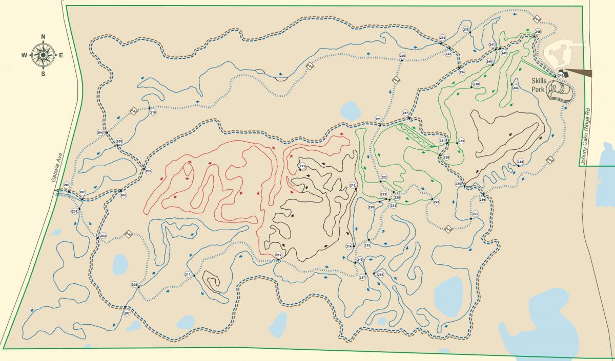 Map of a trail system showing various routes and features, including marked paths in red, green, and blue, along with contour lines, and landmarks. A compass rose indicating north is located in the upper left corner. The map is framed in green and includes labels for specific trails and a skills park area. Lebanon Hills mountain bike trail.