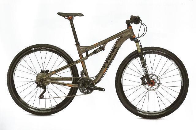 Trek Superfly 100 AL Elite: A modern mountain bike with a sleek gray frame, featuring disc brakes, wide tires, and a front suspension fork, displayed against a white background.