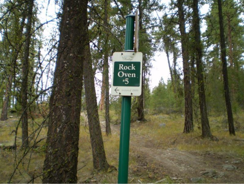 Sign marking "Rock Oven #5" positioned among trees in a natural setting, indicating a trail or point of interest. Tote Road Trail mountain bike trail.
