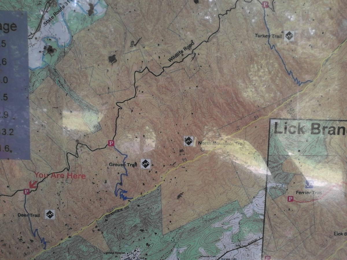 Map of hiking trails in a mountainous area, showing various routes such as Grouse Trail, North Mountain Trail, and Turkey Trail. Marked locations include parking areas and prominent features, with a red label indicating "You Are Here." The terrain is displayed with contour lines and elevation details. Dragon's Back mountain bike trail.