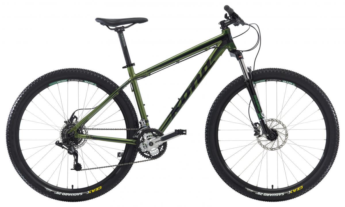 Kona Mahuna: A green mountain bike with a sturdy frame, thick tires, and a comfortable seat, positioned to showcase its dual disc brakes and gear system.