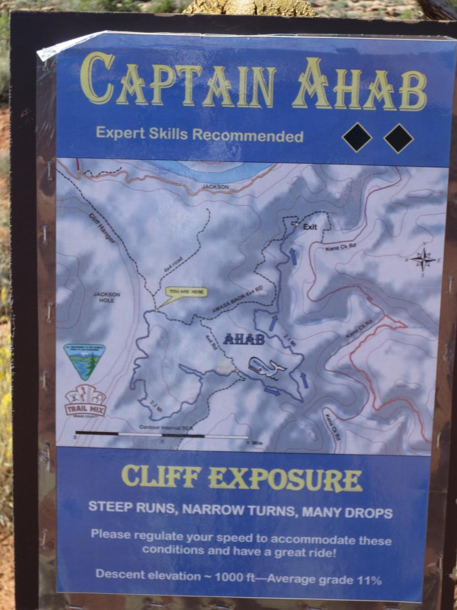 A trail map titled "Captain Ahab," indicating expert-level skills are required. The map outlines the trail's steep runs, narrow turns, and significant drops. Key details include a descent elevation of approximately 1000 feet and an average grade of 11%. The map displays various landmarks and pathways, emphasizing the cliff exposure and requiring caution for riders. Captain Ahab mountain bike trail.