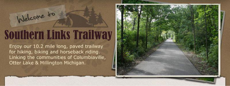A welcoming sign for the Southern Links Trailway, featuring a paved trail surrounded by trees, promoting activities like hiking, biking, and horseback riding, and highlighting its connection between the communities of Columbiaville, Otter Lake, and Millington, Michigan. Southern Links Trailway mountain bike trail.