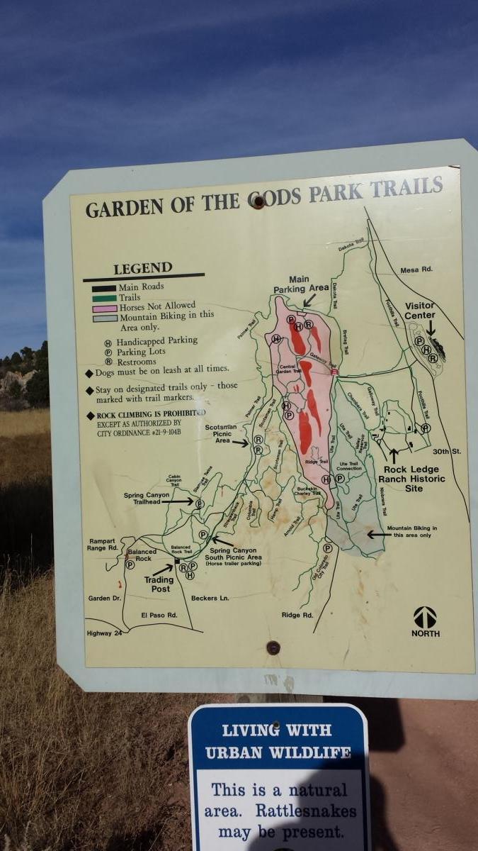 Map of the Garden of the Gods Park Trails, showing main roads, trails, parking areas, and visitor facilities, with a legend indicating restrictions such as no horses allowed and designated mountain biking areas. A warning sign below the map notes the presence of rattlesnakes and encourages caution in this natural area. Garden of the Gods: Ute Trail mountain bike trail.