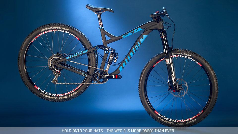 Niner W.F.O. 9: A modern mountain bike, the WFO 9, displayed against a blue background, featuring a sleek black frame with blue accents and equipped with high-performance tires. The bike is shown in a dynamic, floating position to emphasize its design and engineering.