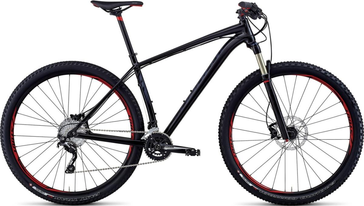 Specialized Crave Comp 29: A black mountain bike with red accents, featuring a sturdy frame, thick tires, and a front suspension fork. The bike is positioned at an angle, showcasing its gear system and disc brakes.