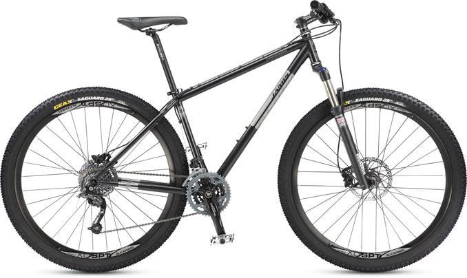 Jamis 2013 Dragon 29 Sport: A black mountain bike with a lightweight frame, featuring wide tires and a front suspension fork. The bike has disc brakes, a chain drivetrain with multiple gears, and a sleek design, suitable for off-road riding and outdoor adventures.