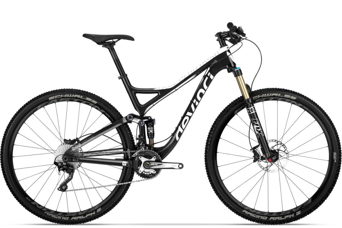 Devinci Atlas Carbon RC: Mountain bike with a black frame, featuring front suspension, dual disc brakes, and high-performance tires. The bike is designed for off-road cycling, showcasing a lightweight structure with a sloped top tube and a modern geometric design.
