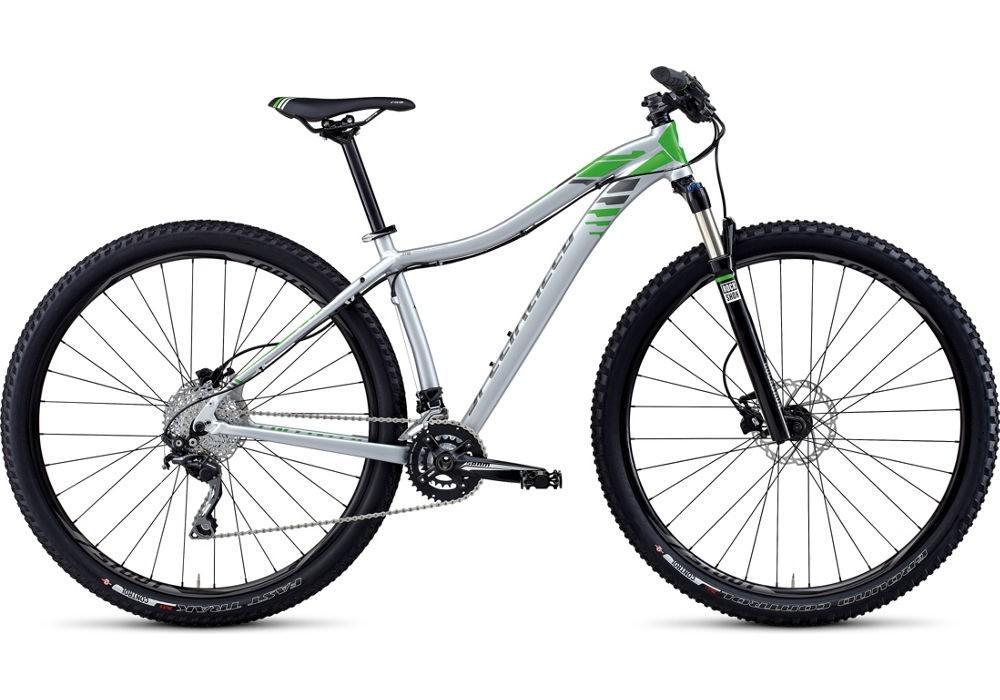 Specialized JETT COMP 29: Alt tag: "Side view of a modern mountain bike featuring a silver frame with green accents, thick black tires, and a front suspension fork."