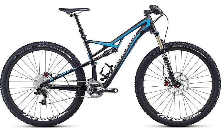 Specialized Camber Expert Carbon 29: A black and blue mountain bike featuring a full suspension design, wide tires, and disc brakes. The bike has a lightweight frame and is equipped with a front fork designed for off-road performance.