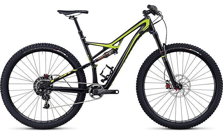 Specialized Camber Expert Carbon EVO 29: A black and yellow mountain bike featuring a lightweight frame, dual suspension system, and large knobby tires suitable for off-road terrain. The bike is positioned on a plain background, showcasing its sleek design and gear components.
