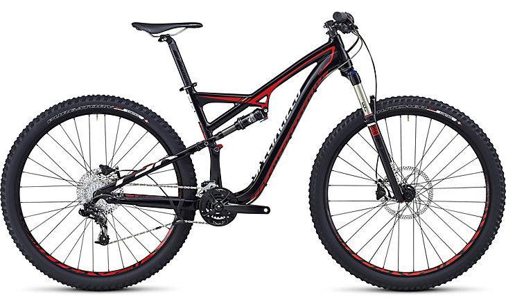 Specialized Camber EVO 29: A black and red mountain bike featuring a lightweight frame, dual suspension, and wide, knobby tires, designed for off-road biking. The bike is equipped with disc brakes and a precision gear system, suitable for rugged terrains.