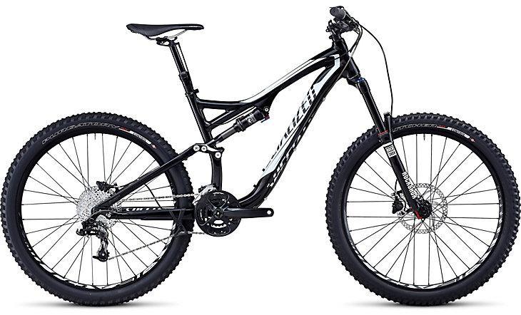 Specialized Stumpjumper FSR Comp EVO: A black and white mountain bike with a sleek design, featuring large knobby tires, a dual suspension system, and a modern gearing setup. The bike is positioned on a white background, showcasing its frame and components clearly.