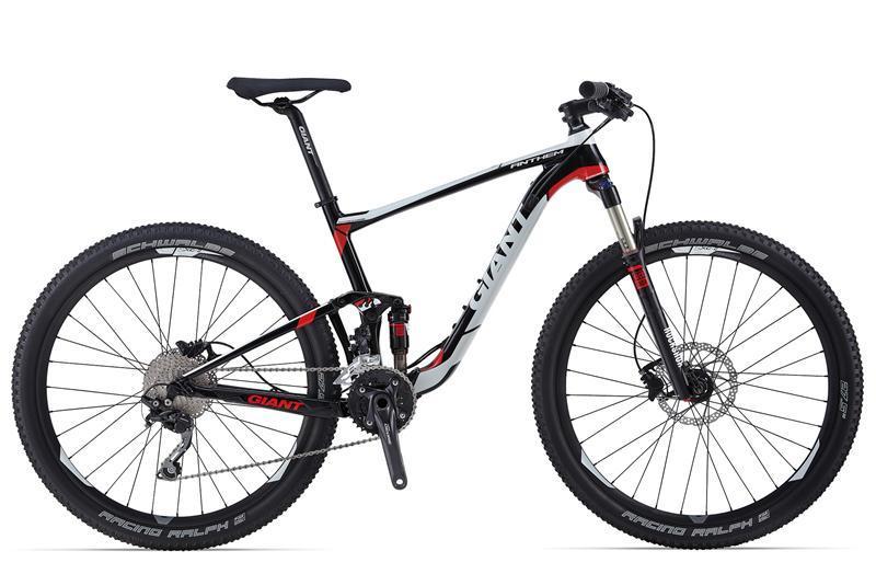 Giant Anthem 27.5 3: Mountain bike with a black and red frame, featuring a sleek design, disc brakes, and wide tires. The bike has a prominent brand logo and is positioned against a neutral background, showcasing its various components like the gears and suspension system.