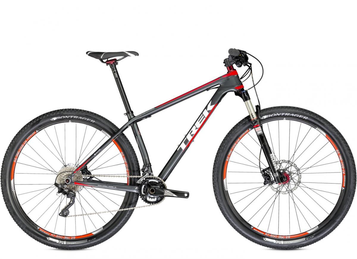 Trek Superfly 9.6: A modern mountain bike featuring a sleek black and red frame, with a front suspension fork and disc brakes. The bike is equipped with wider tires for off-road performance and a gear system visible along the chainstay. The seat is raised, and the handlebars are adjusted for a comfortable riding position.