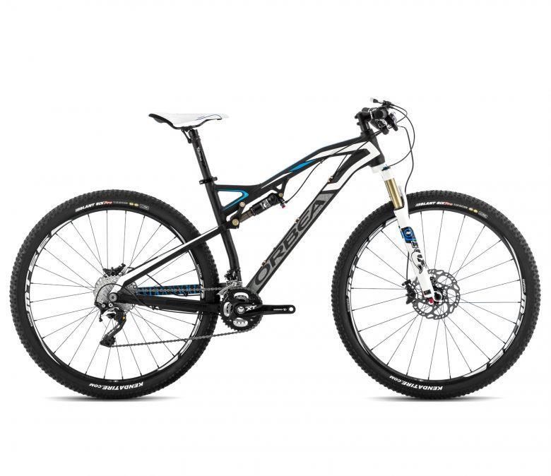Orbea Occam 29 H10: A black and blue Orbea mountain bike, featuring a sleek frame design, front suspension fork, and wide tires suitable for off-road riding. The bike has disc brakes and a white saddle, presented against a plain background.