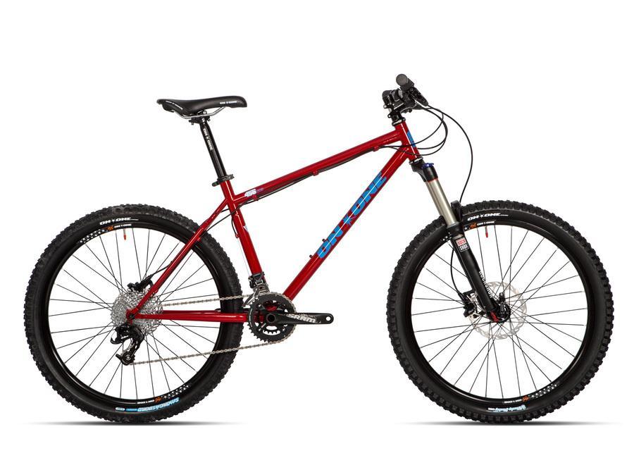 On-One 456 Evo2: A red mountain bike with a sturdy frame, featuring a suspension fork, wide tires, and disc brakes, positioned against a plain background. The bike has a blue and white logo on the frame and is equipped with a gear system.