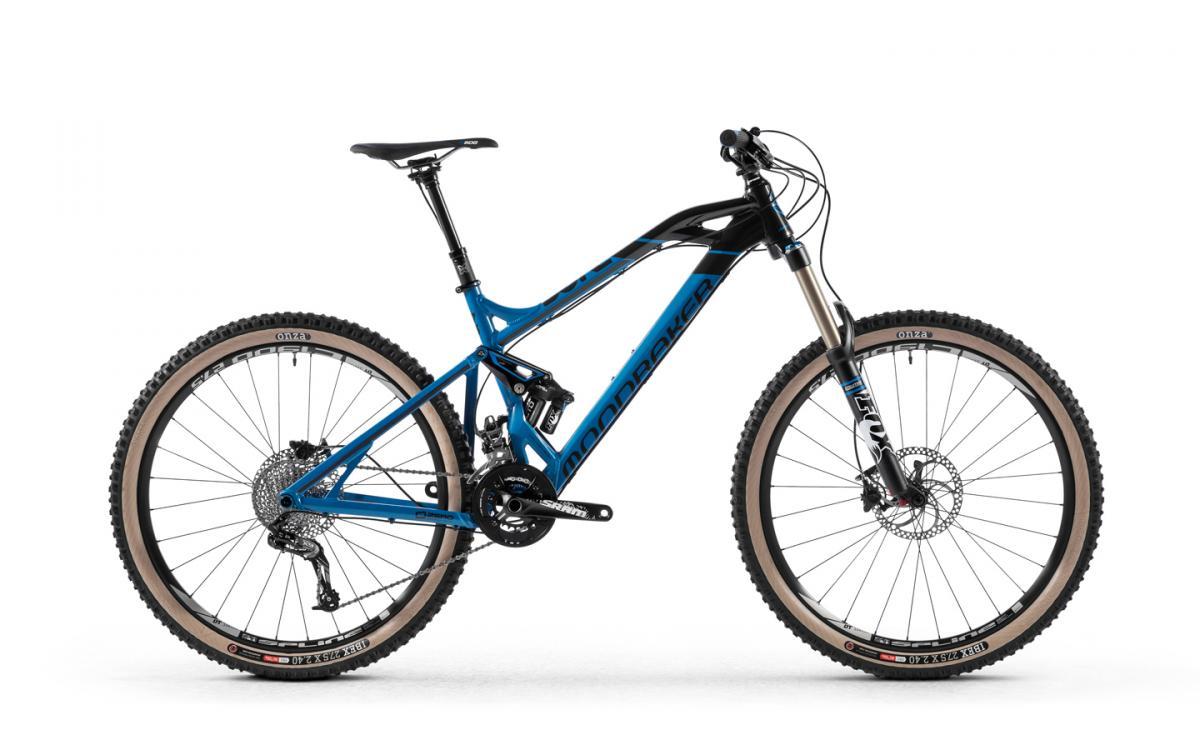 Mondraker Dune R: A blue and black mountain bike with a sleek design and large tires, featuring a front suspension fork and disc brakes. The bike is positioned on a white background, showcasing its frame, gears, and handlebars.