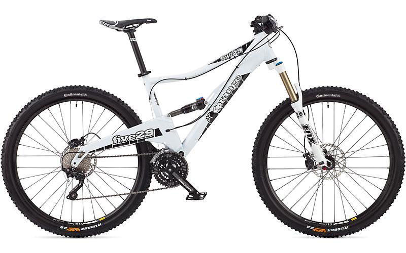 Orange Five 29 Pro: A white mountain bike with front suspension, wide tires, and a prominent frame design. The bike features components from various brands, including gears and brakes, suitable for off-road riding.