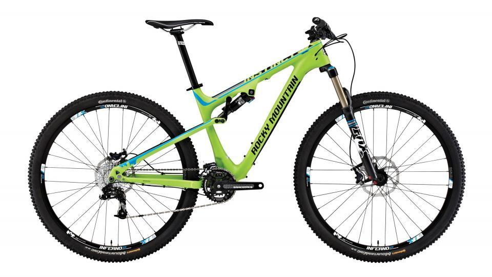 Rocky Mountain Instinct 950 MSL: Mountain bike with a vibrant green and blue frame, featuring front suspension, thick tires, and disc brakes. The bike is positioned on a clean white background, highlighting its sleek design and components.