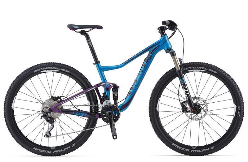 Giant Lust 2: A blue and purple mountain bike with a sleek design, featuring a lightweight frame, front suspension fork, and disc brakes. The bike has knobby tires suitable for off-road terrain and a modern drivetrain.