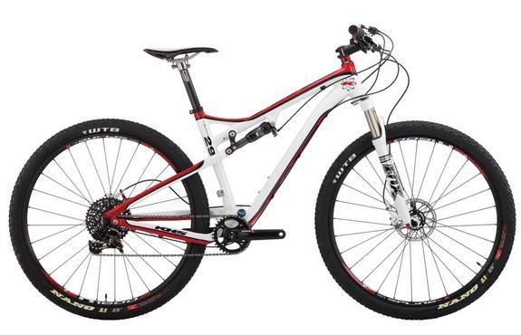 KHS Team 29 FS: A modern mountain bike featuring a sleek white and red frame, equipped with wide black tires, front suspension, and disc brakes. The bike is designed for performance and stability on rugged terrain, showcasing its lightweight construction and advanced components.