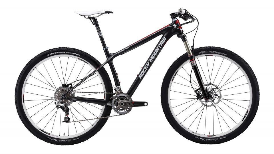 Rocky Mountain Vertex: A black and red Rocky Mountain mountain bike, featuring a lightweight frame, disc brakes, and knobby tires, positioned against a plain white background. The bicycle showcases a modern design suitable for off-road trails.