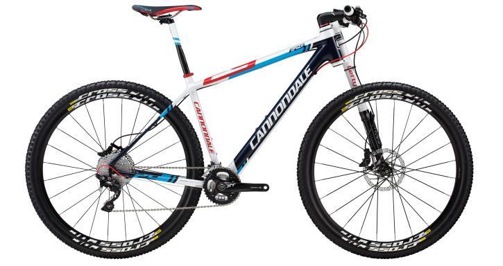Cannondale F29 Carbon 2: Alt text: A Cannondale mountain bike featuring a sleek white, blue, and red design, equipped with thick tires and front suspension, positioned against a plain background.