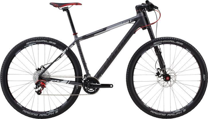 Cannondale F29 Carbon 3: A modern mountain bike with a sleek, lightweight frame featuring a matte gray finish and red accents. The bike includes front suspension, disc brakes, and high-performance tires designed for off-road terrain. It is positioned against a plain white background.