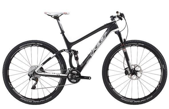 Felt Edict Nine 1: A sleek black and white mountain bike featuring a lightweight carbon frame, front suspension, and wide tires designed for optimal traction. The bike is equipped with disc brakes and features a modern design suitable for off-road cycling.