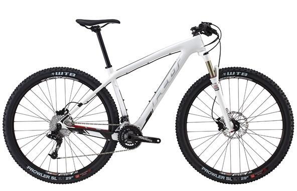 Felt Nine 3: A sleek, white mountain bike with a lightweight frame, front suspension fork, and disc brakes. It features black tires with a rugged tread pattern, designed for off-road cycling. The bike has a modern design, with a minimalist aesthetic and gear components visible on the frame.