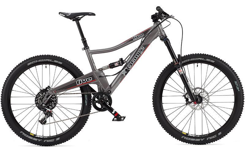 Orange Five RS: A modern mountain bike with a gray frame, featuring dual suspension, wide tires, and disc brakes. The bike is designed for off-road use, showcasing both durability and performance, with noticeable branding on the frame.