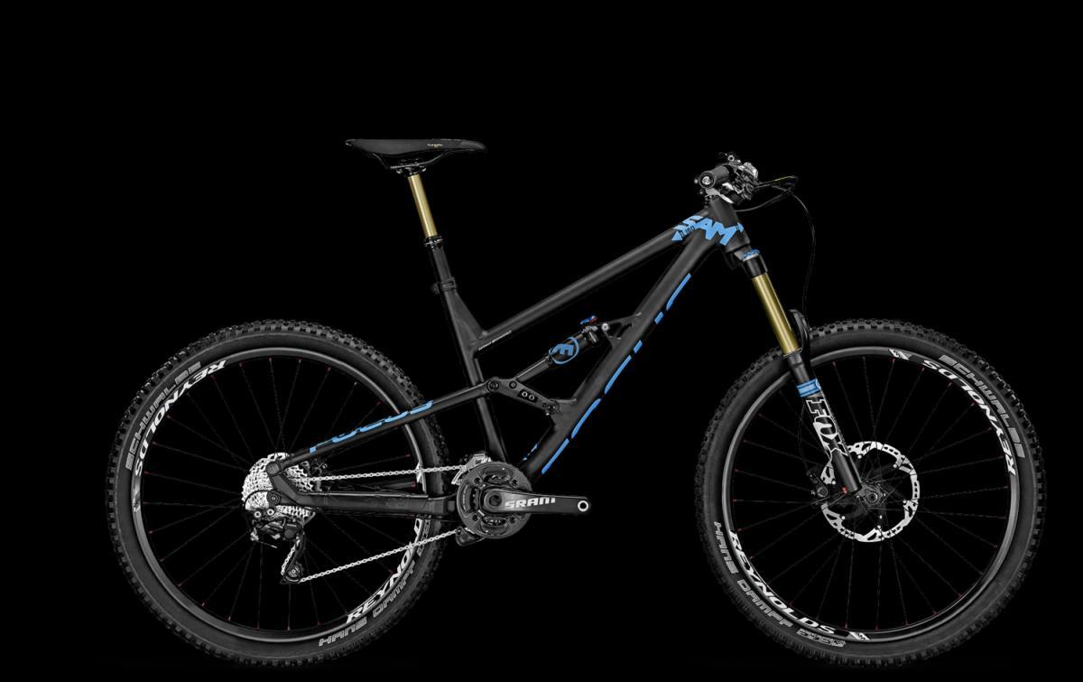 Focus Sam 2.0: A modern mountain bike with a sleek black and blue frame, featuring front suspension and large knobby tires, set against a black background. The bike showcases high-quality components including SRAM drivetrain and Fox suspension, designed for off-road performance.