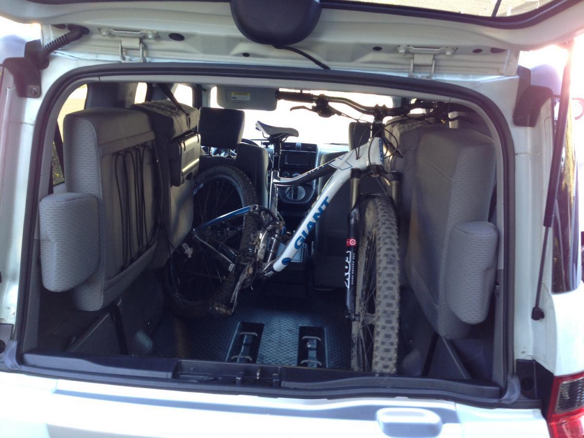 Giant Trance X 29er: Alt tag: "Interior view of a vehicle trunk with a mountain bike securely stored, showing the rear seats folded down and the bike positioned diagonally."