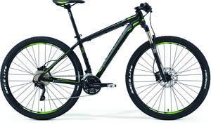 Merida Big.Nine 500: A black and green mountain bike, featuring thick tires, a sturdy frame, and disc brakes, positioned on a white background.