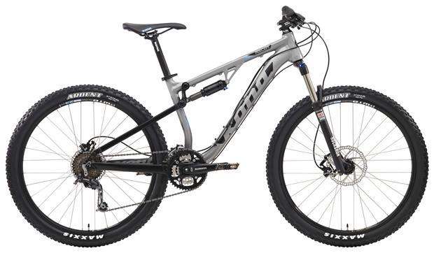 Kona Precept: A silver and black mountain bike with a lightweight frame, front suspension, and wide tires, designed for off-road cycling. The bike includes disc brakes and features a geared drivetrain with several chainrings and gears.