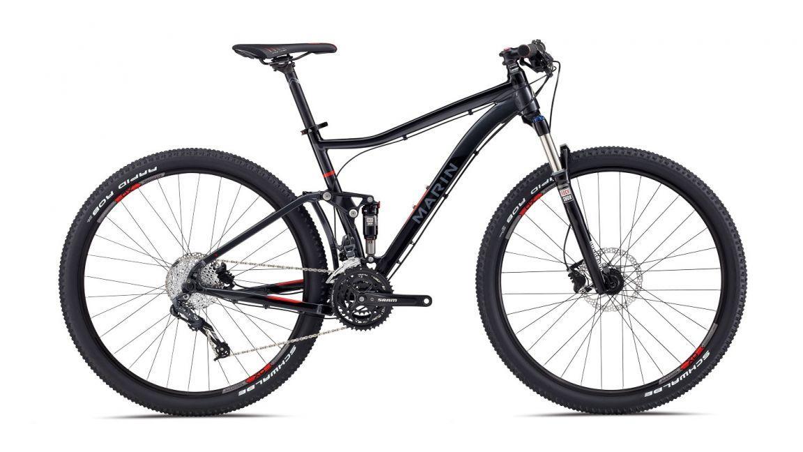 Marin Rift Zone 29er XC6: A black mountain bike with a sleek frame, equipped with front suspension and disc brakes, showcasing wide tires and a modern design. The bike features a branded gear system and detailed components like the saddle and handlebars.